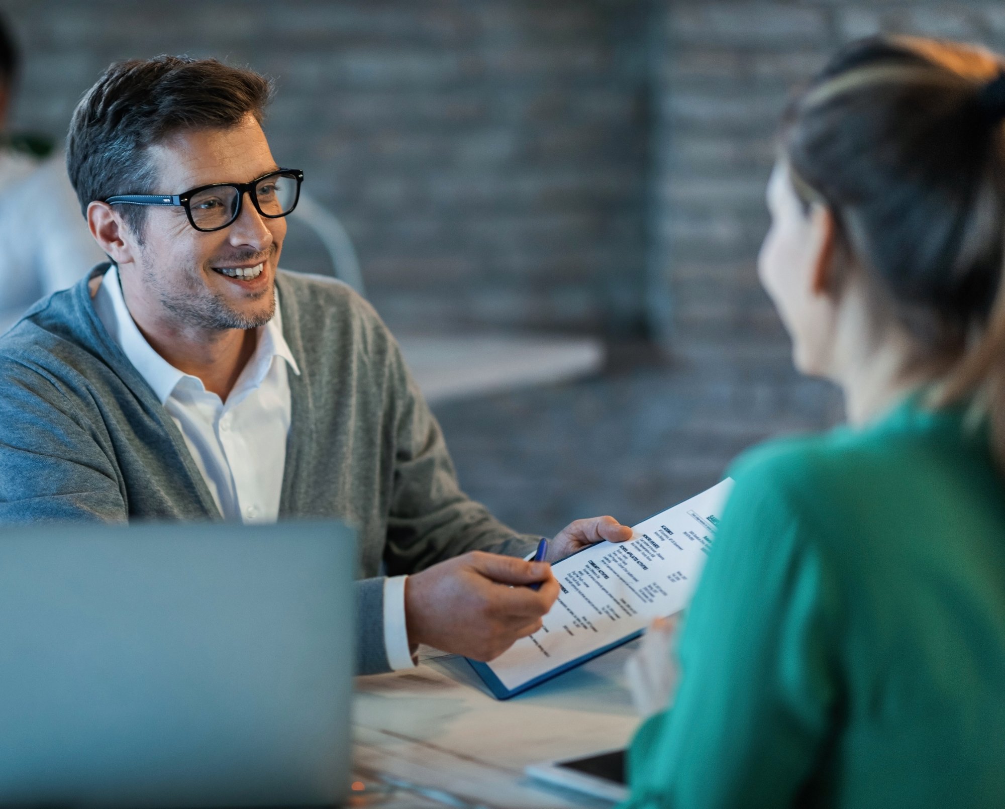 happy-businessman-talking-his-colleague-while-going-through-financial-reports-office-1