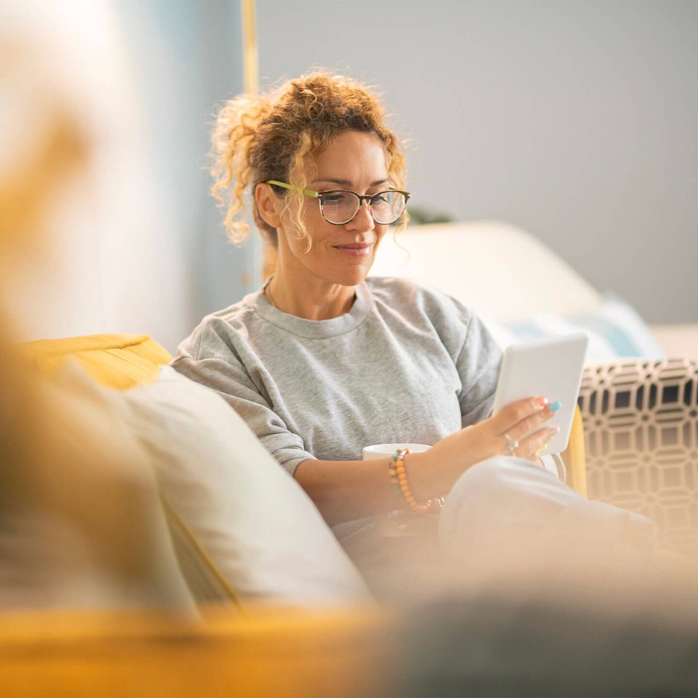 young-mature-woman-smile-enjoy-time-reading-electronic-book-tablet-reader-device-comfortably-sitting-sofa-home-indoor-leisure-activity-alone-female-people-have-relax-indoor 2